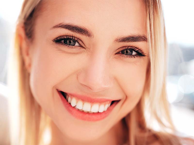 Person smiling for a dental emergency guide